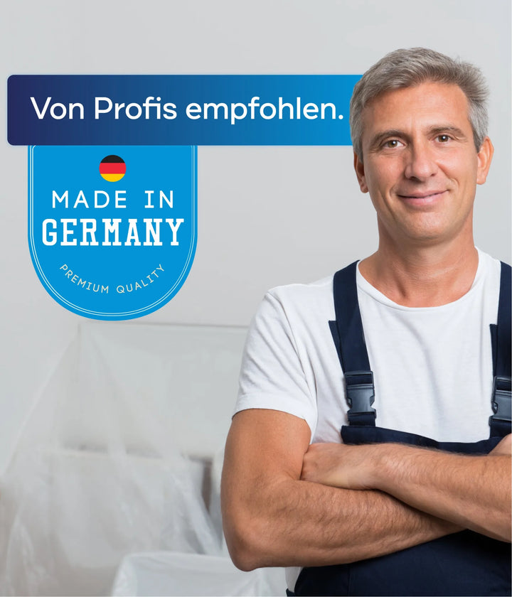 Ein lächelnder Mann im Arbeitsoverall steht mit verschränkten Armen neben einem Schild: Von Profis empfohlen. Hergestellt in Deutschland. Premium Quality by plid - Silikon Fassadenfarbe Anstreichset mit Abdeckvlies, ideal für wetterbeständige Fassadenrenovierung.