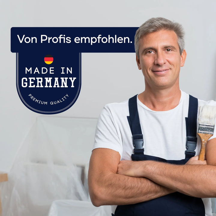 Ein lächelnder Mann in Latzhose mit einem Pinsel steht neben einem Schild: Von Profis empfohlen. Hergestellt in Deutschland. Premium Qualität, mit der deutschen Flagge und der Hervorhebung von plid Holzlasur für innen &amp; außen - wetterfest &amp; atmungsaktiv.