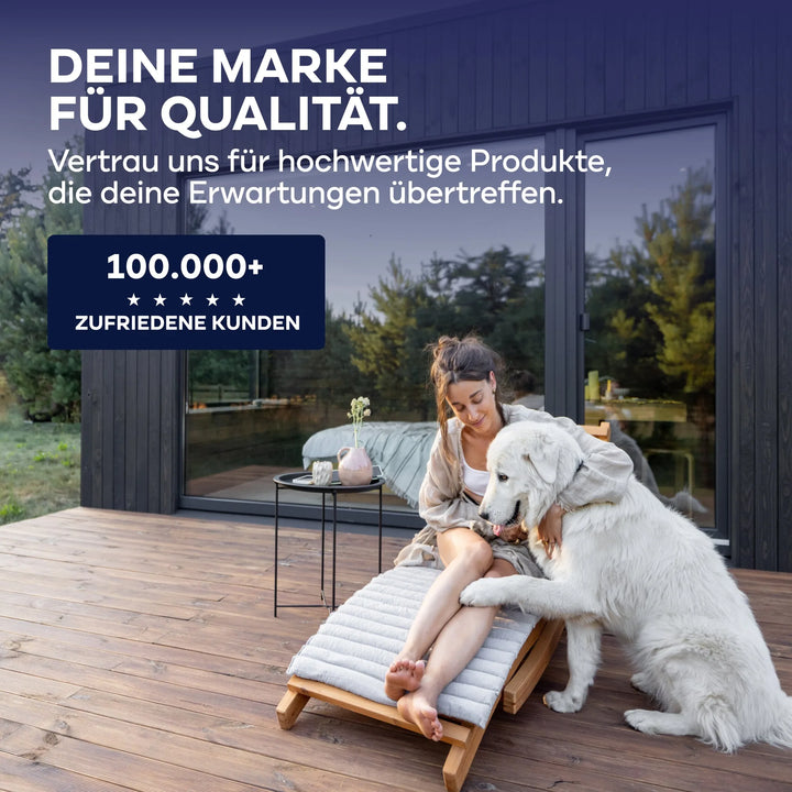 Eine Frau sitzt auf einer Holzterrasse, lächelt und streichelt ihren weißen Hund vor einem modernen Haus. Text in Deutsch wirbt für plid Plid® Möbellack Innen &amp; Außen - Buntlack für Möbel &amp; Holz, perfekt für hochwertige Holzoberflächen im Innen- und Außenbereich.