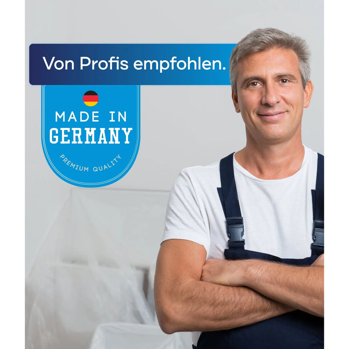 Ein Mann in Latzhose steht mit verschränkten Armen und lächelt. Neben ihm steht ein blaues Schild mit der deutschen Flagge: "Von Profis empfohlen. Made in Germany. Premium Quality." Das plid Fassadenfarbe - Anstreichset ist ideal für Innenanstrich und lösemittelfreien Tiefgrund.