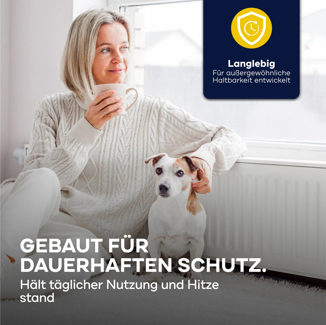 Eine Frau in einem kuscheligen Pullover sitzt mit ihrem weiß-braunen Hund am Fenster und hält eine Tasse. Deutscher Text wirbt für das plid Heizkörperlack LH Premium Set hitzebeständig weiß zur Heizkörpersanierung. Oben rechts ist eine blau-gelbe Qualitätsplakette.