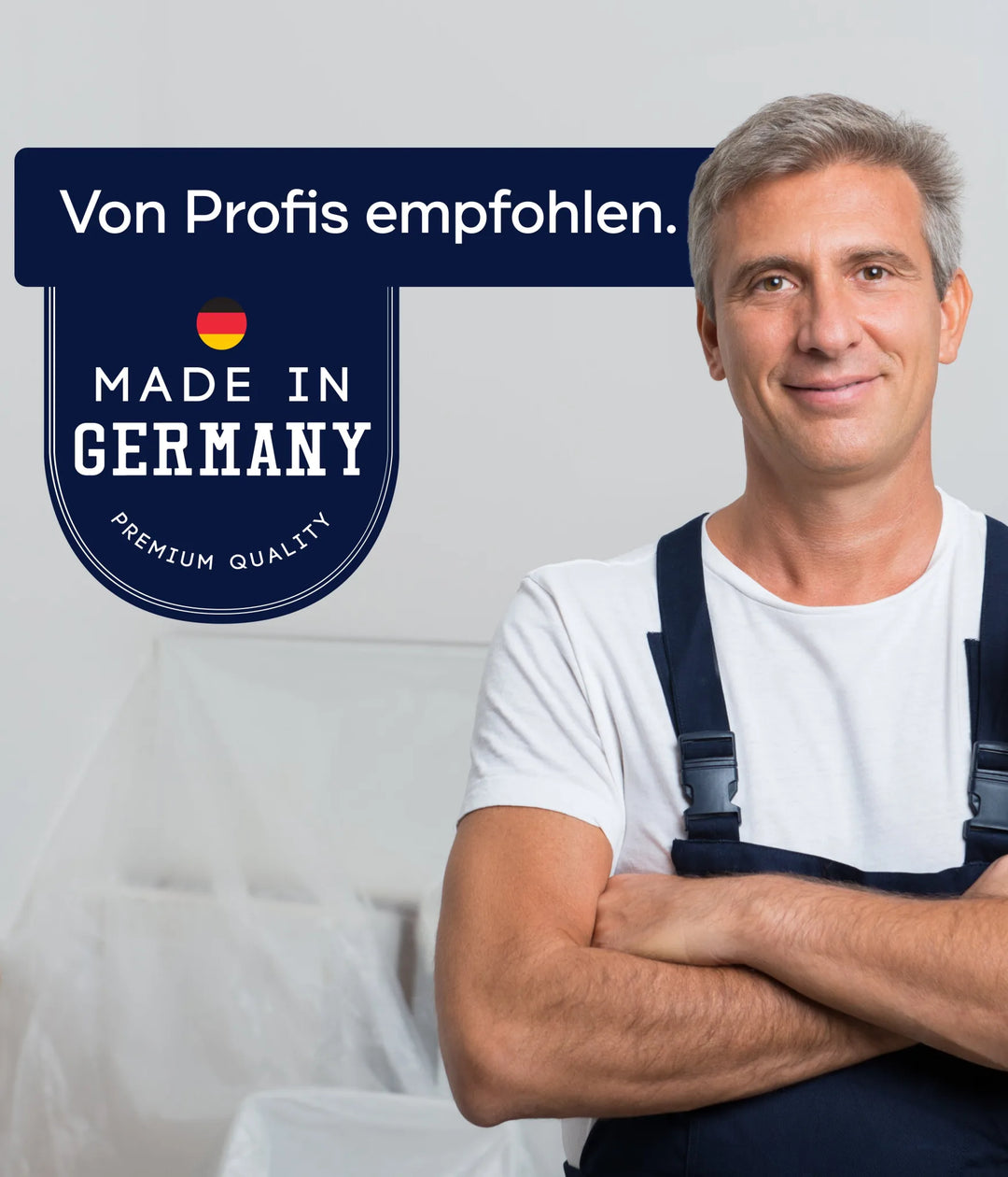 Ein selbstbewusster Mann im Arbeitsoverall steht lächelnd mit verschränkten Armen da. Neben ihm steht ein Schild mit der Aufschrift "Von Profis empfohlen. Made in Germany." plid Parkettlack Anstreichset glänzend/Satin für Holzböden - Premium Qualität, mit deutscher Flagge. Einfarbiger Raumhintergrund.